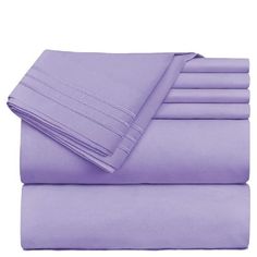 purple sheets and pillowcases are stacked on top of each other