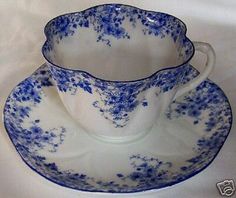 two blue and white tea cups with saucers