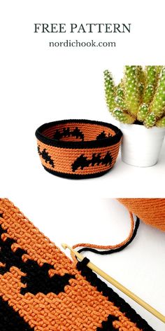 an orange and black crochet bag with bats on it, sitting next to a potted plant