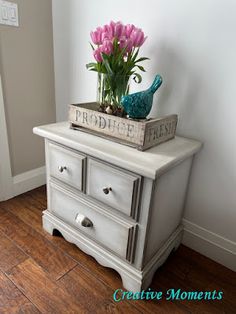 a white dresser with pink flowers on top