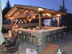 an outdoor kitchen with lights on the roof