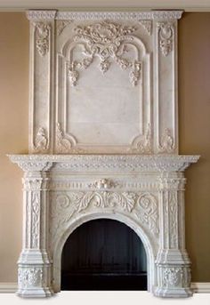 a white fireplace with ornate carvings on the mantle