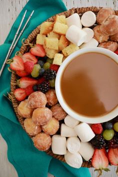 a platter filled with fruit, marshmallows, and coffee