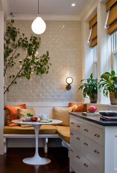 a kitchen with a table and some plants on the counter next to a window sill