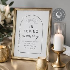 a white and gold framed print with the words in loving memory next to some candles