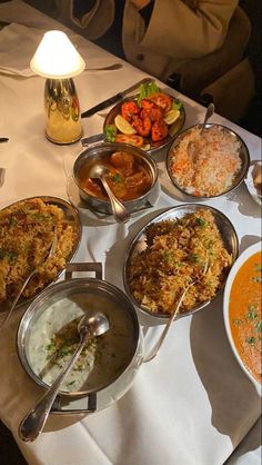 a table filled with lots of different types of food on top of white cloths