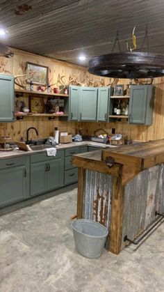 a rustic kitchen with green cabinets and an island