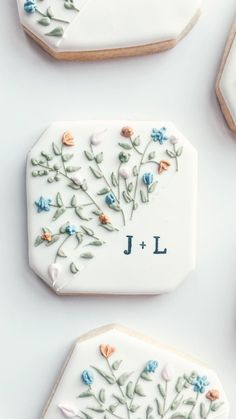 cookies decorated with flowers and the initials j and l on them are laid out next to each other