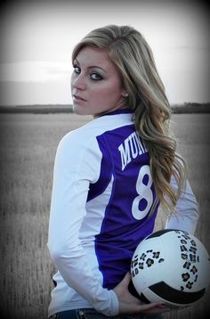 a woman holding a soccer ball in her hands