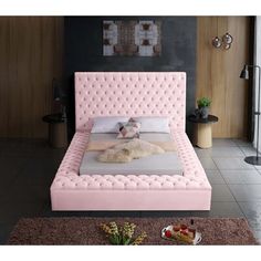 a bedroom with a pink bed frame and pillows on the headboard, along with other furniture