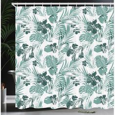 a shower curtain with green leaves on it