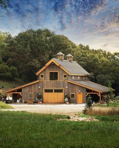 an image of a large barn in the country side with lots of trees and grass