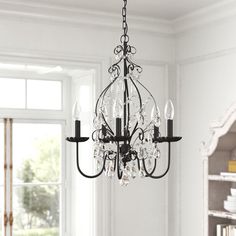 a chandelier hanging from the ceiling in a room with white walls and windows