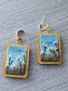 These earrings were hand embroidered by myself and would make the perfect gift for the nature lover or floral enthusiast in your life. Main Features: - Pendant was designed and hand embroidered by myself - The flowers were embroidered using DMC thread on fabric that was painted with watercolor - Pendant measures 1.75" x 1" - The total length of the earring is 2" - These earrings have gold stud attachments - If you would like silver instead or would prefer a hook finding, please DM me! If you are giving this as a gift and would like a note attached, please let me know. Instagram: Follow me @lemonsandthreadco for more embroidery content Contact: If you have any questions about this piece, please don't hesitate to contact me through Etsy Messenger or by email at lemonsandthreadco@gmail.com Th Watercolor Pendant, Daisies Watercolor, Embroidered Jewelry, Dmc Thread, Wooden Earrings, Gold Stud, Floral Earrings, Gold Studs, Craft Fairs