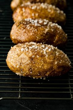 three sugar covered donuts sitting on top of a cooling rack next to each other