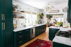 a kitchen with dark green cabinets and white counter tops, an area rug on the floor