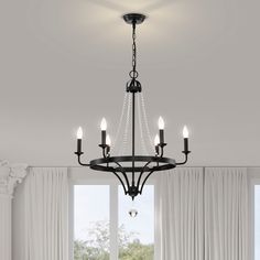 a chandelier hanging from the ceiling in a room with white walls and curtains