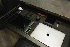 an apple laptop computer sitting on top of a wooden table next to other electronics and gadgets