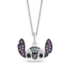 a necklace with purple and white crystals on it, featuring a small bat shaped pendant