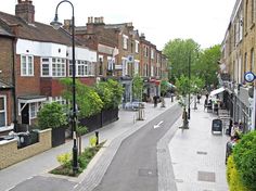 an empty city street with people walking on the sidewalks