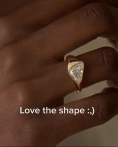 a woman's hand with a ring on it that says love the shape