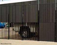 a truck is parked behind a metal fence