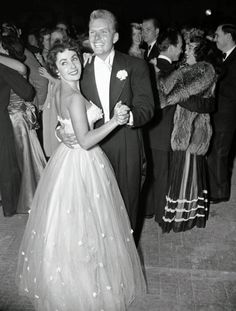 a man in a tuxedo hugging a woman in a ball gown on the dance floor