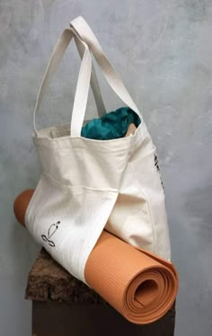 a yoga mat and tote bag sitting on top of a wooden block