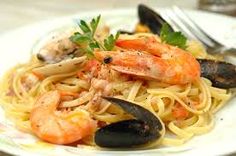 a white plate topped with pasta and shrimp