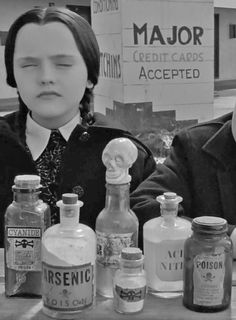 an old black and white photo of two people sitting at a table full of liquor bottles