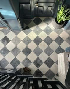 a kitchen with black and white checkered tile on the wall, stove top and oven