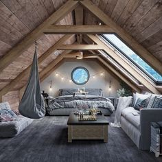 an attic bedroom is decorated in gray and white with lots of natural wood beams, exposed lighting, and a hammock hanging from the ceiling