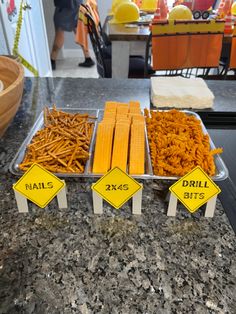 three trays filled with different types of fries on top of a counter next to each other