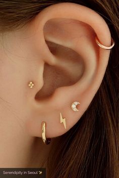 an ear with three different piercings on the top and one has a lightning bolt