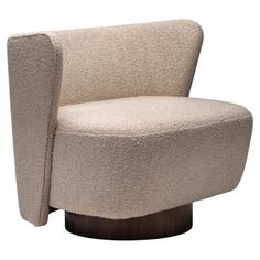 an upholstered chair with a wooden base and armrests, in cream colored fabric