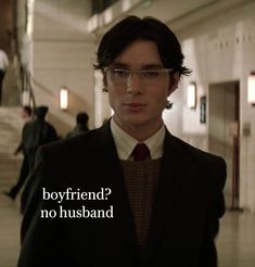 a young man wearing glasses and a suit with the words boyfriend? no husband on it