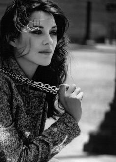 black and white photograph of a woman leaning on a pole