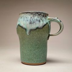 a green and white coffee cup sitting on top of a table