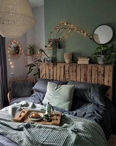 a bed room with a tray on top of it and lights hanging above the headboard