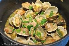 clams are being cooked in a pot on the stove