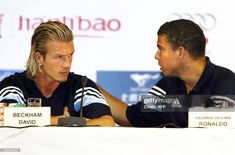 two men sitting at a table talking to each other