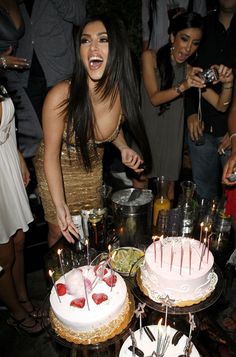 a woman is cutting a cake at a party