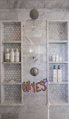 a bathroom with hexagonal tiles and shelves filled with personal care products on the wall