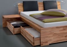 a bed with two drawers underneath it and a pillow on the bottom one that is open