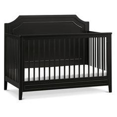 a black crib with white sheets on the bottom and bottom part, in front of a