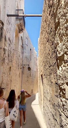 two girls walking down an alley way in the old city