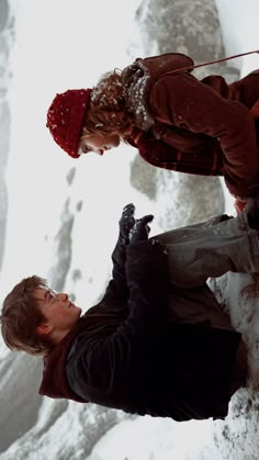 two people standing next to each other in the snow