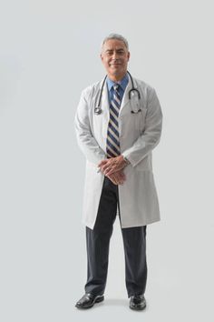 a male doctor in a white coat and tie standing with his hands on his hips