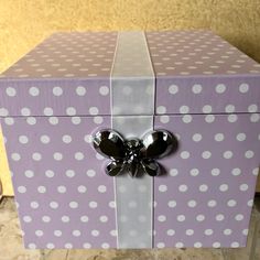 a purple box with white polka dots and a bow