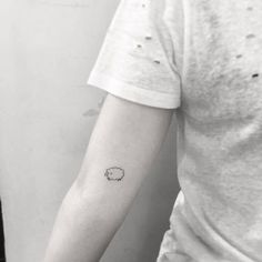 a small sheep tattoo on the left inner arm and wrist, with an ink spot in the middle